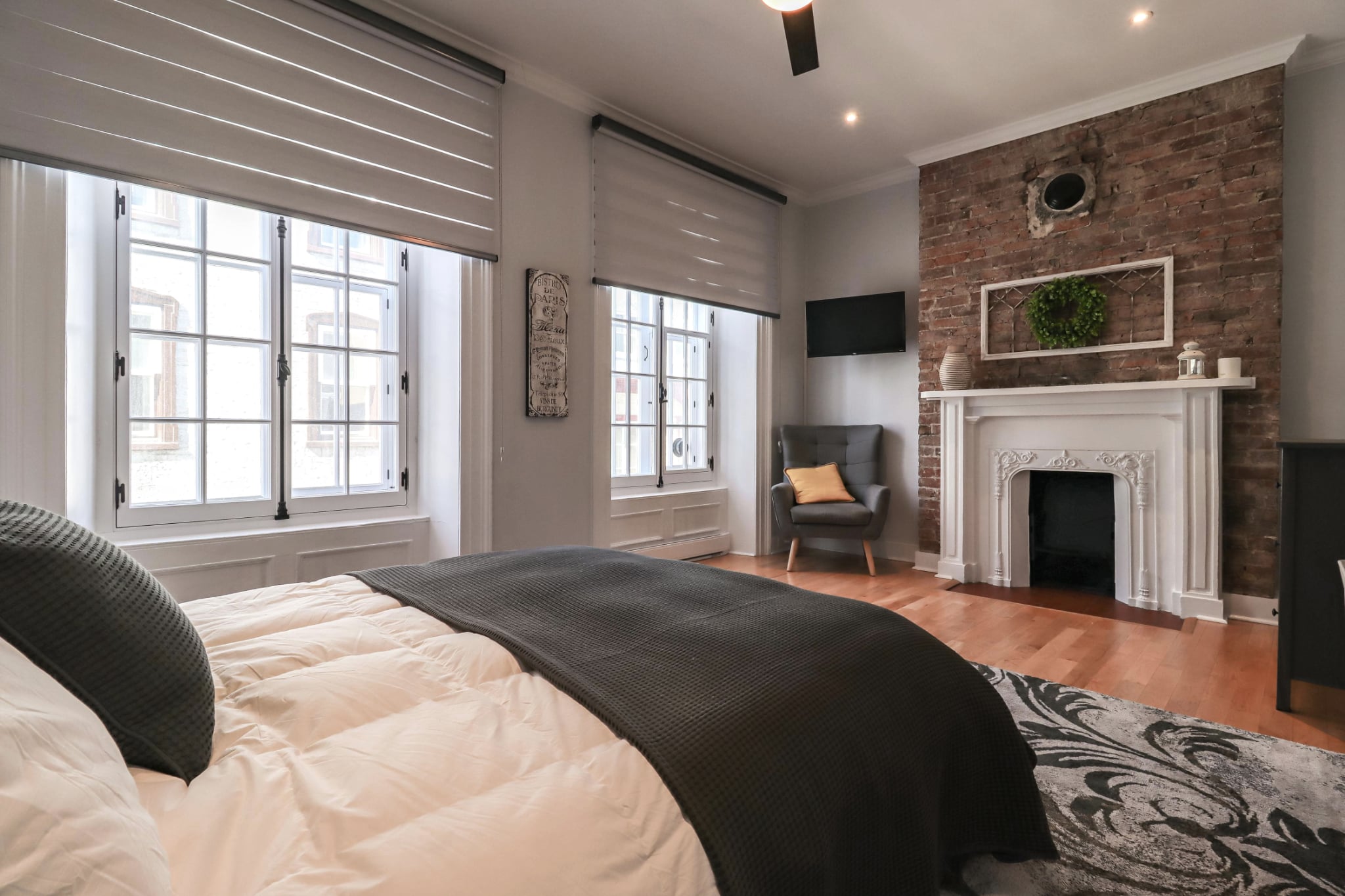 Chambre avec foyer décoratif et mur de brique